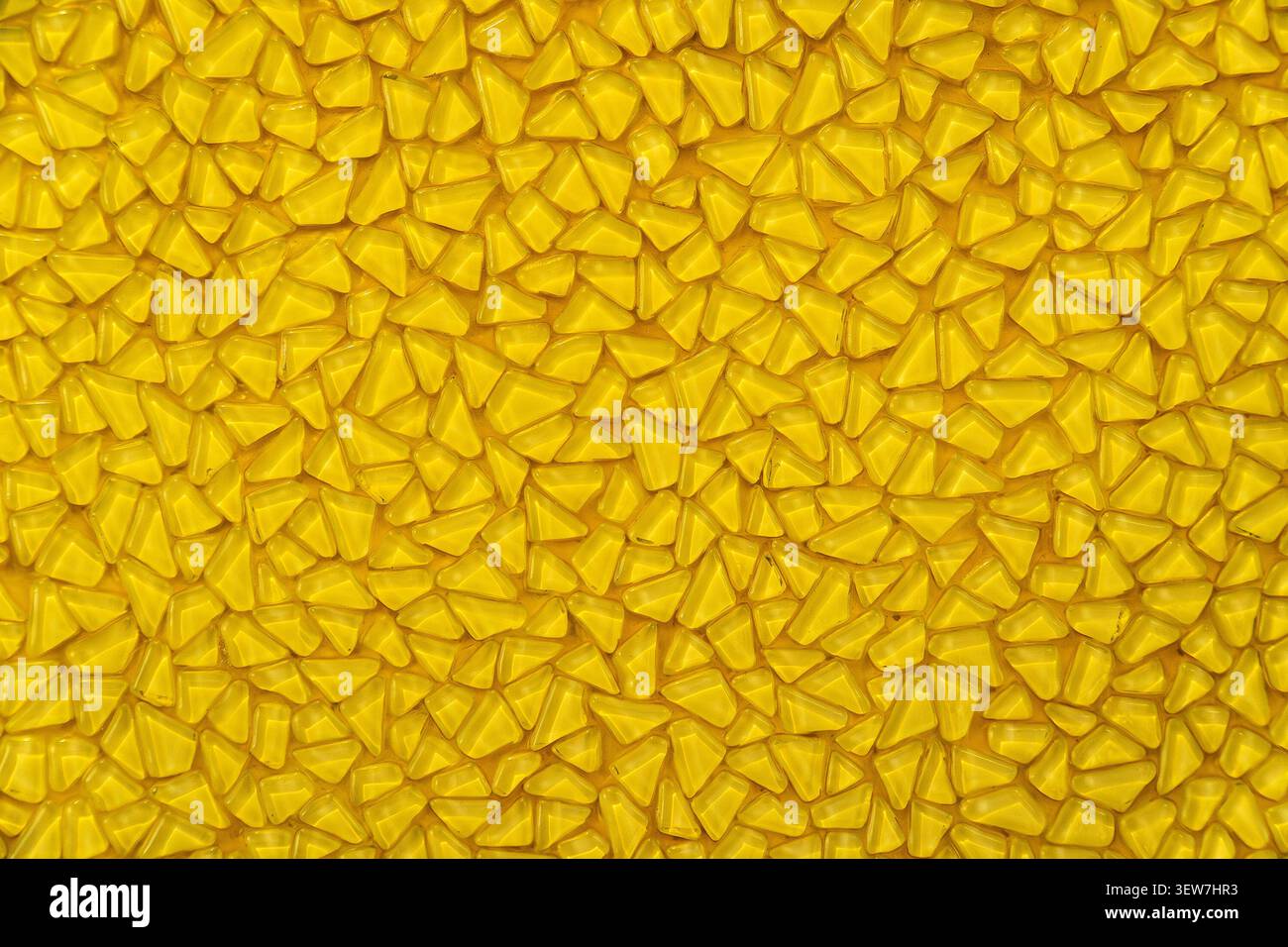 Yellow mosaic pattern background with small triangular glass tiles. Stock Photo