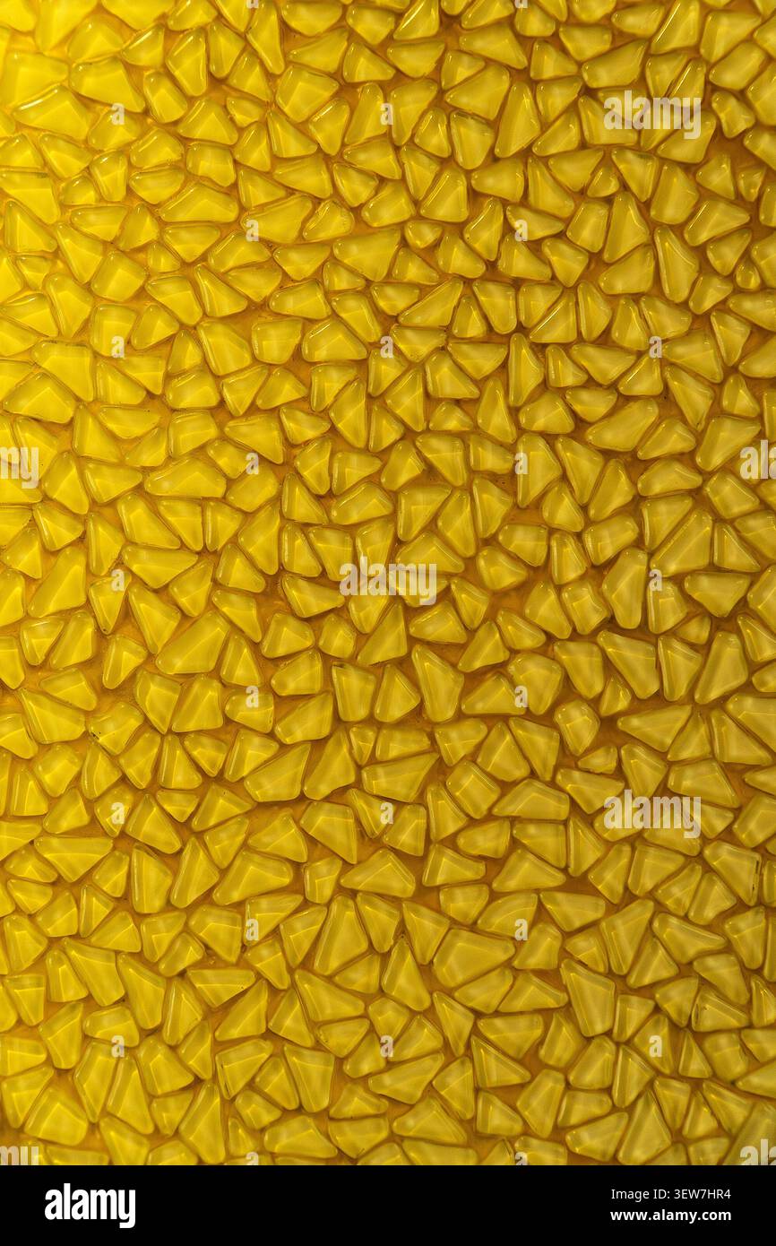 Yellow mosaic pattern background with small triangular glass tiles. Stock Photo