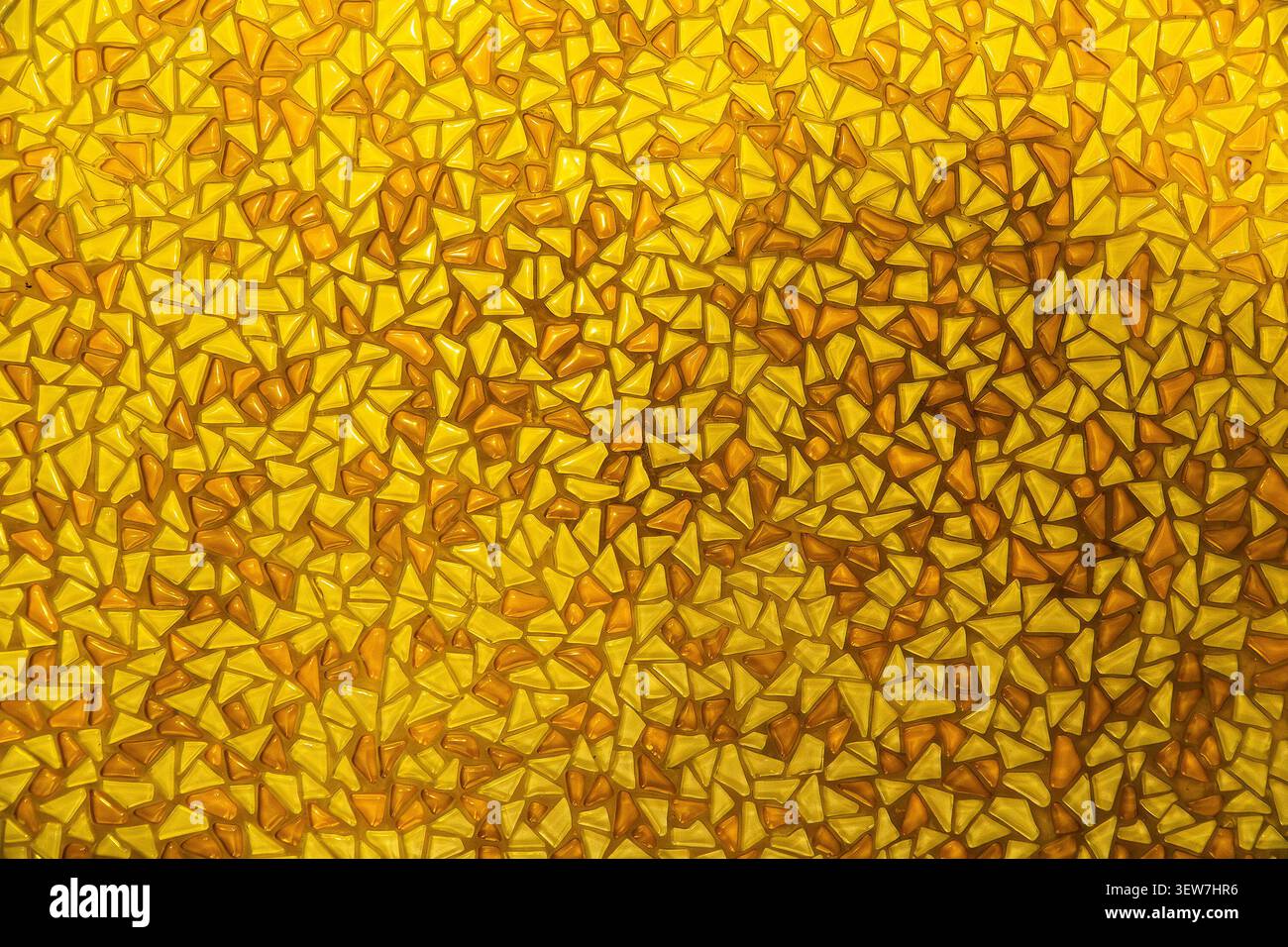Yellow mosaic pattern background with small triangular glass tiles. Stock Photo