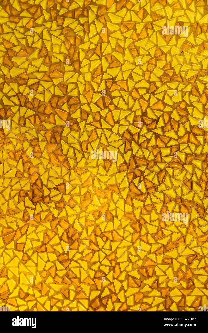 Yellow mosaic pattern background with small triangular glass tiles. Stock Photo