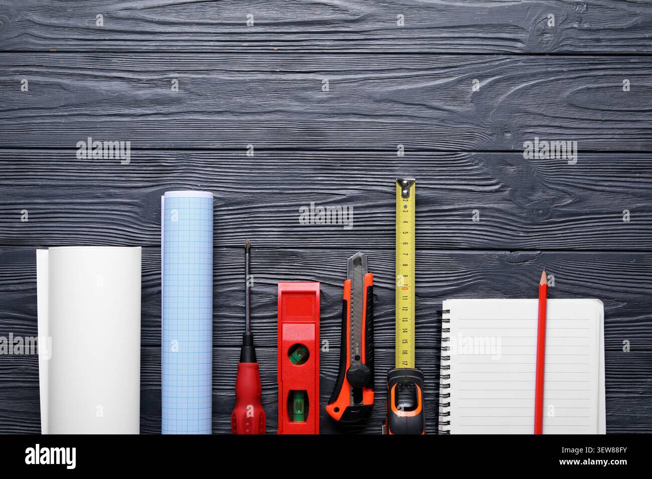 Construction tools and blueprint on dark wooden surface Stock Photo