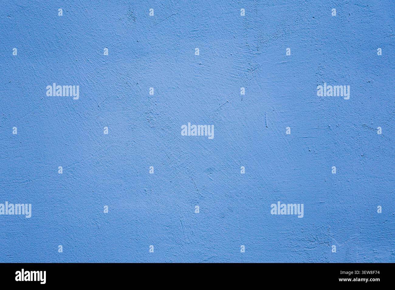 Full frame texture of a vibrant blue painted stucco wall with fine grains and subtle imperfections. This rough cement plaster background is perfect fo Stock Photo