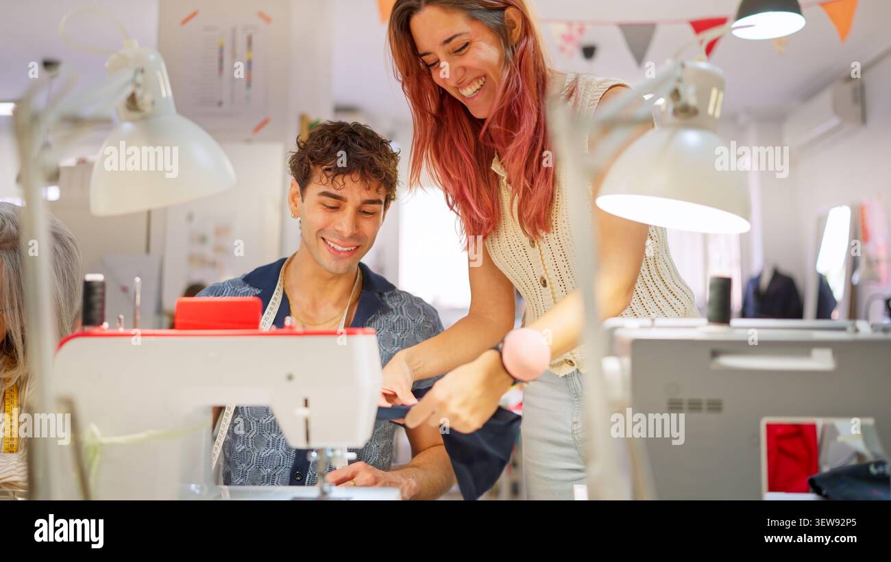 Instructors guiding student learning sewing machine in workshop Stock Photo