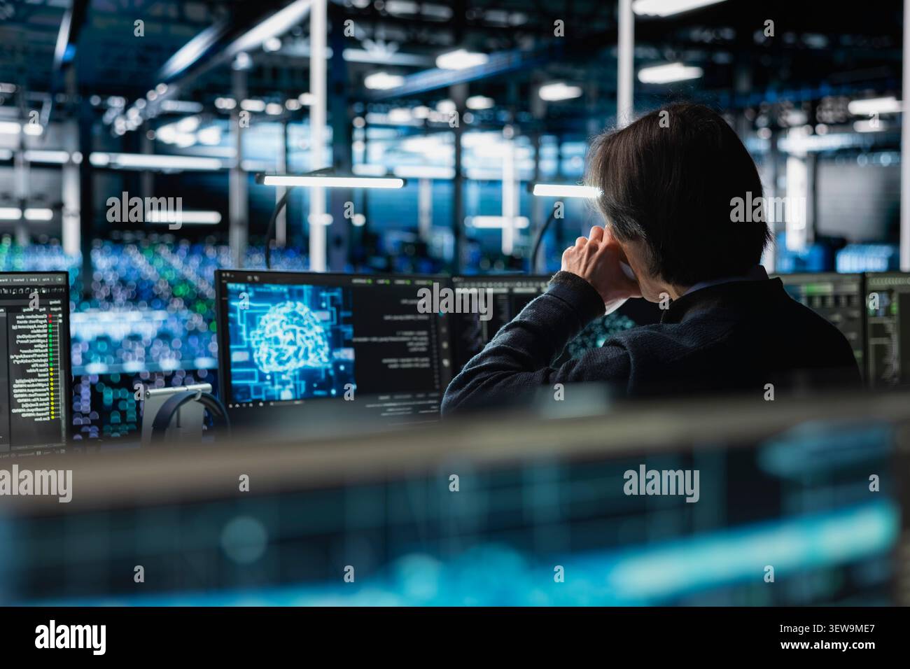 Data center programmer uses a digital device in a data center to manage AI systems and optimize server infrastructure. Stock Photo