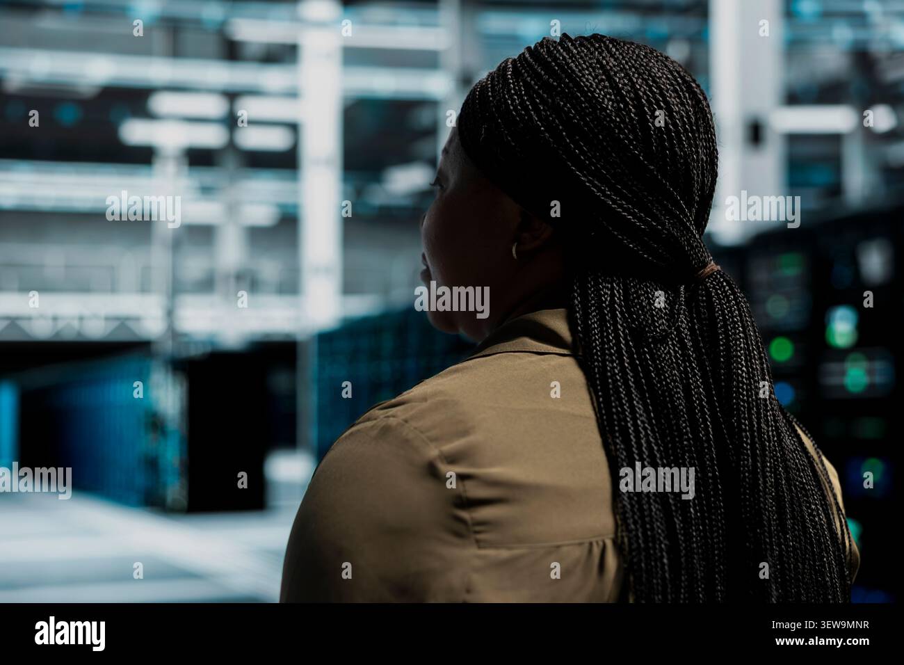 Data center technician uses a desktop computer in a data center to support failure detection and reliable server workflows. Stock Photo