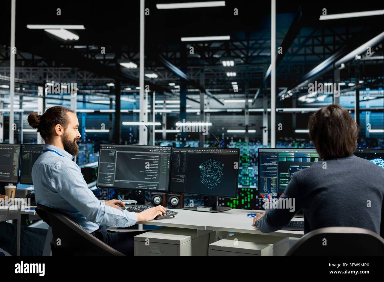 Data center programmers use a desktop computer in a data center to manage AI systems and optimize server infrastructure. Stock Photo