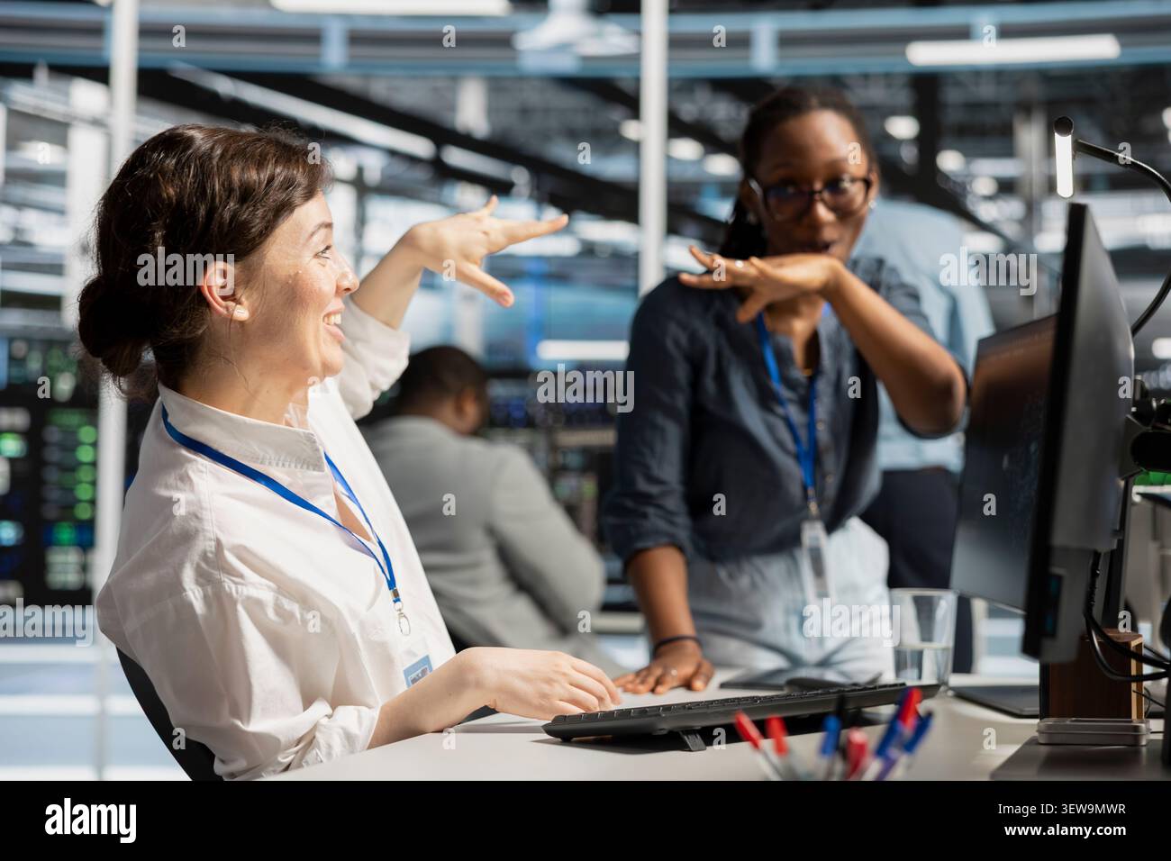 Cheerful engineering team celebrates improved system results in a data center after improved performance and completed server operations. Stock Photo