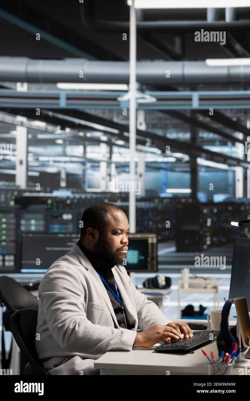System administrator reviews performance analytics on a desktop computer in a data center to optimize storage systems and resource use. Stock Photo