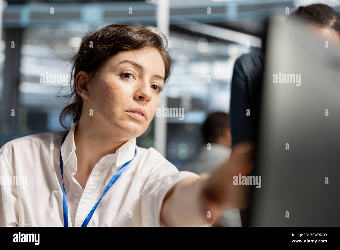 Data center engineer uses a digital device in a data center to run hardware diagnostics and maintain operational stability. Stock Photo
