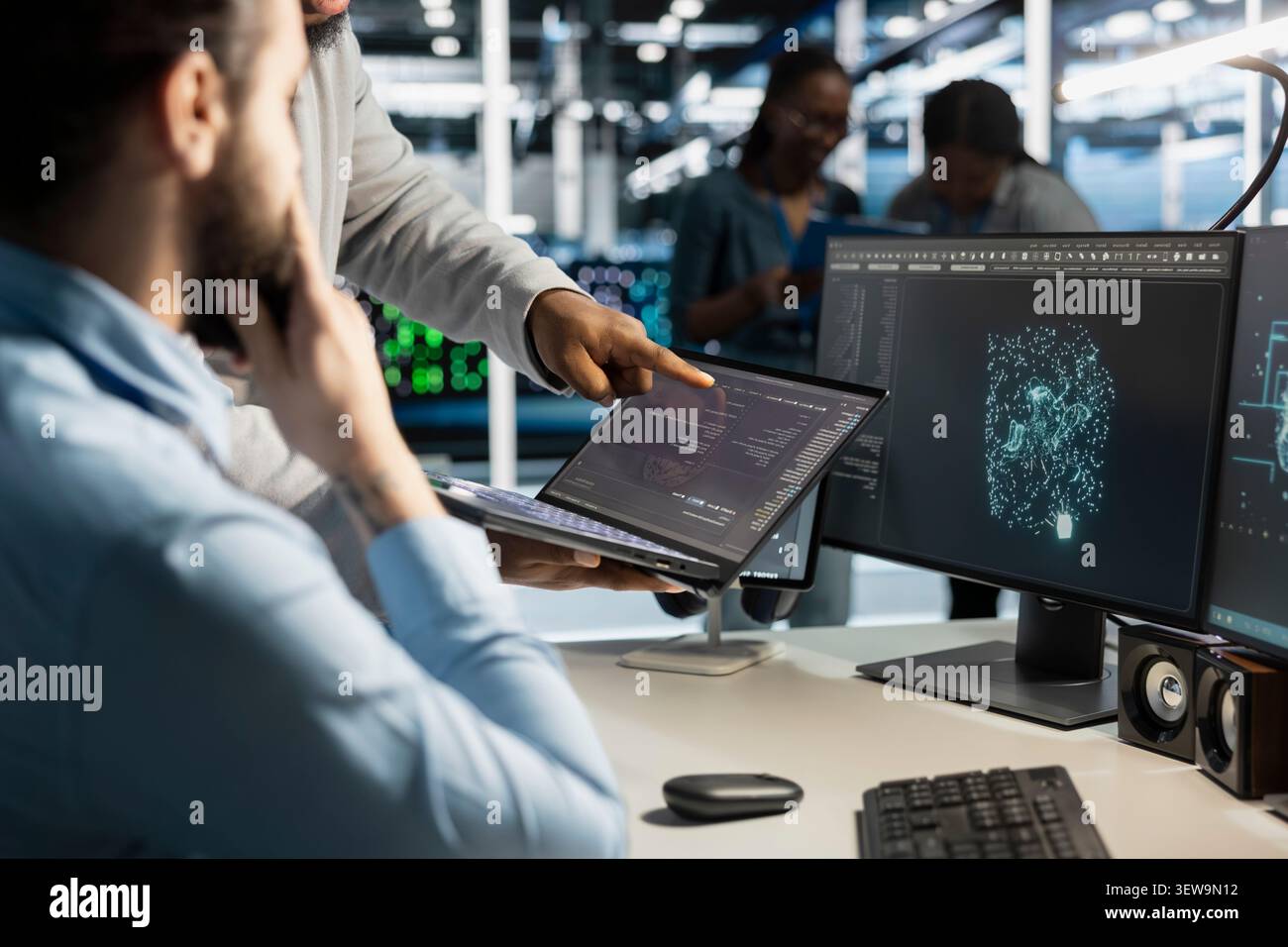 Concerned data center team reviews warning messages in a data center while troubleshooting errors affecting equipment performance. Stock Photo