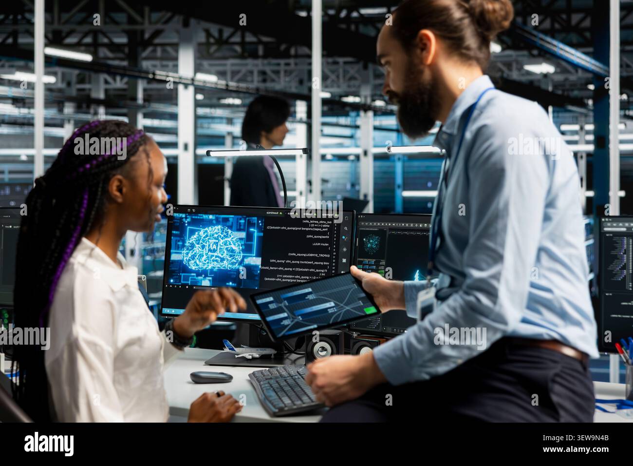 Software developer reviews artificial intelligence systems and machine learning processes inside a data center. Stock Photo