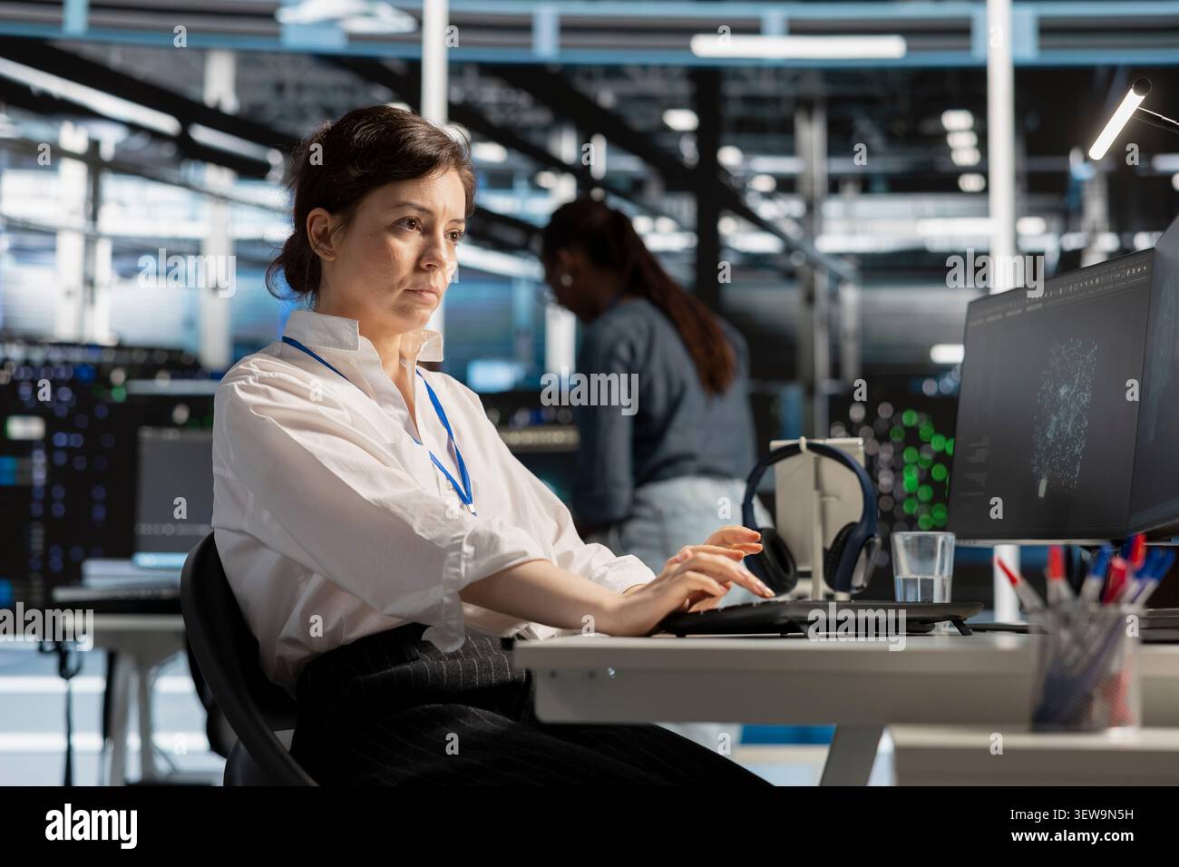 Computer scientist uses a computer to run diagnostics, update servers and check infrastructure performance. Stock Photo