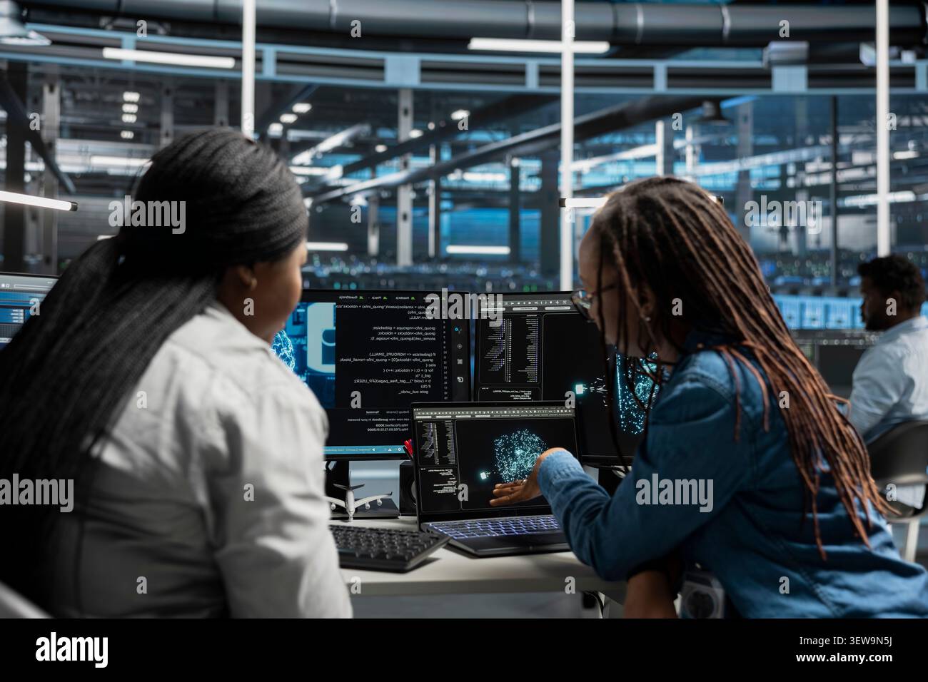 System administrator reviews artificial intelligence systems and machine learning processes inside a data center. Stock Photo