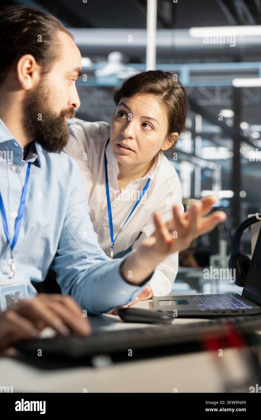 Data center colleagues collaborate on technical analysis and server infrastructure management inside a high-tech facility. Stock Photo