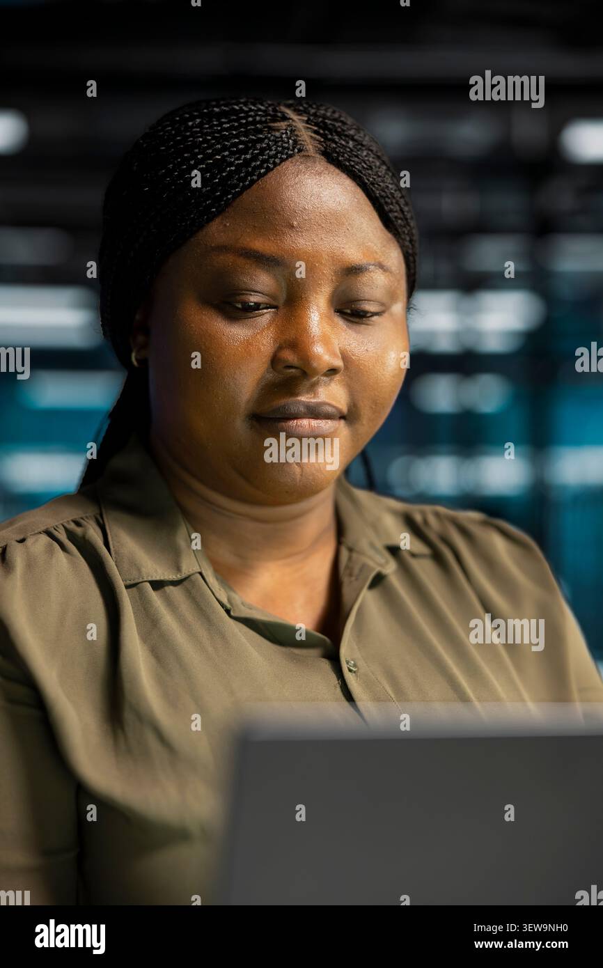 Data center engineer inspects server infrastructure, performs maintenance checks and reviews equipment diagnostics. Stock Photo