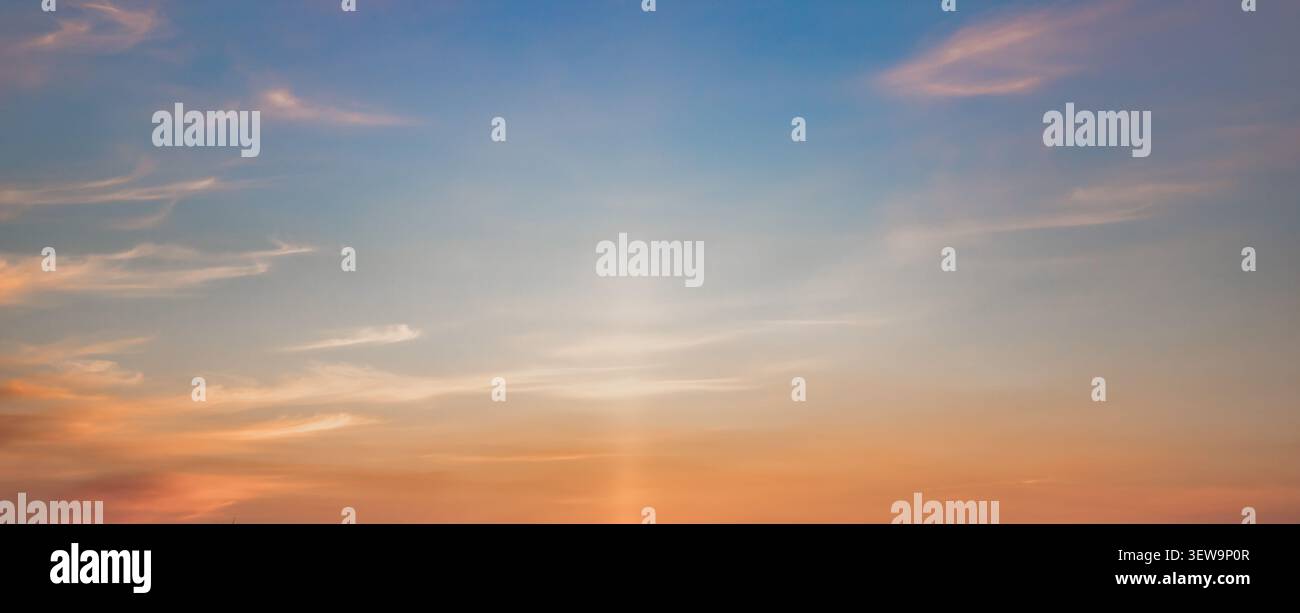 Colorful Sunset Sky With Soft Clouds and Dramatic Sun Rays Background Stock Photo