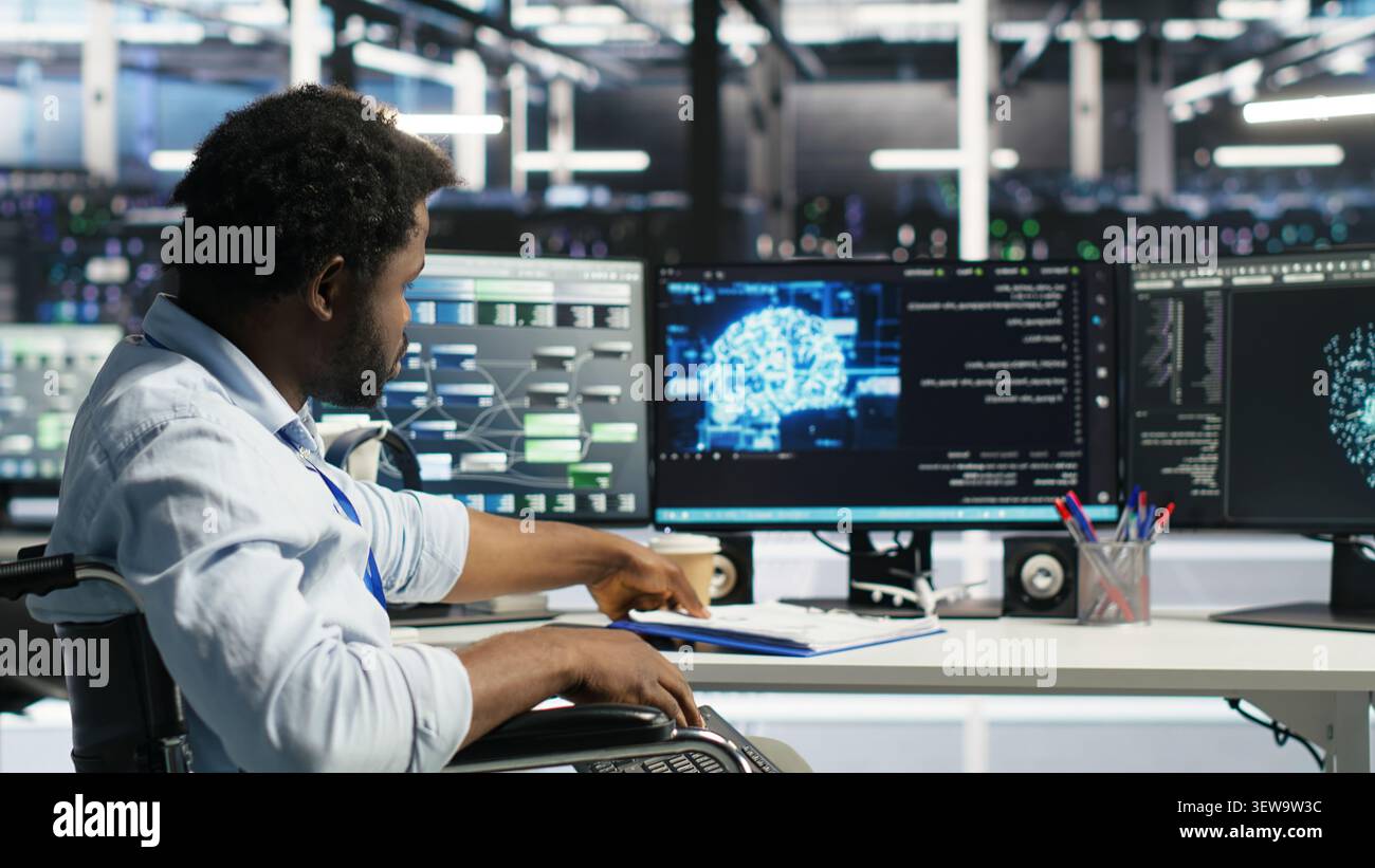 Data center admin in a wheelchair receives paperwork from a colleague while using AI node tree software. Stock Photo