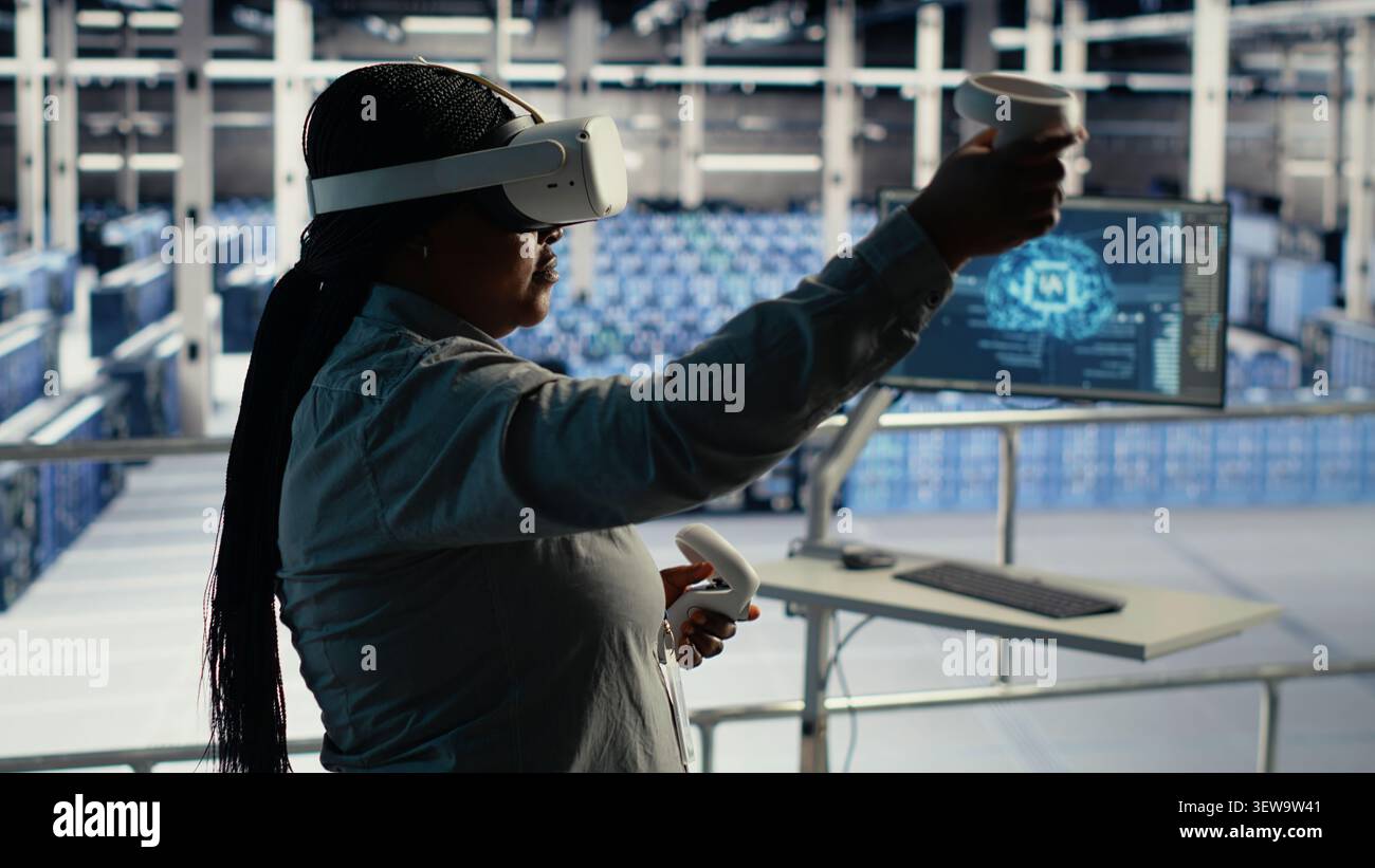 Data center engineer uses a VR headset to review AI diagnostics and manage server system performance. Stock Photo