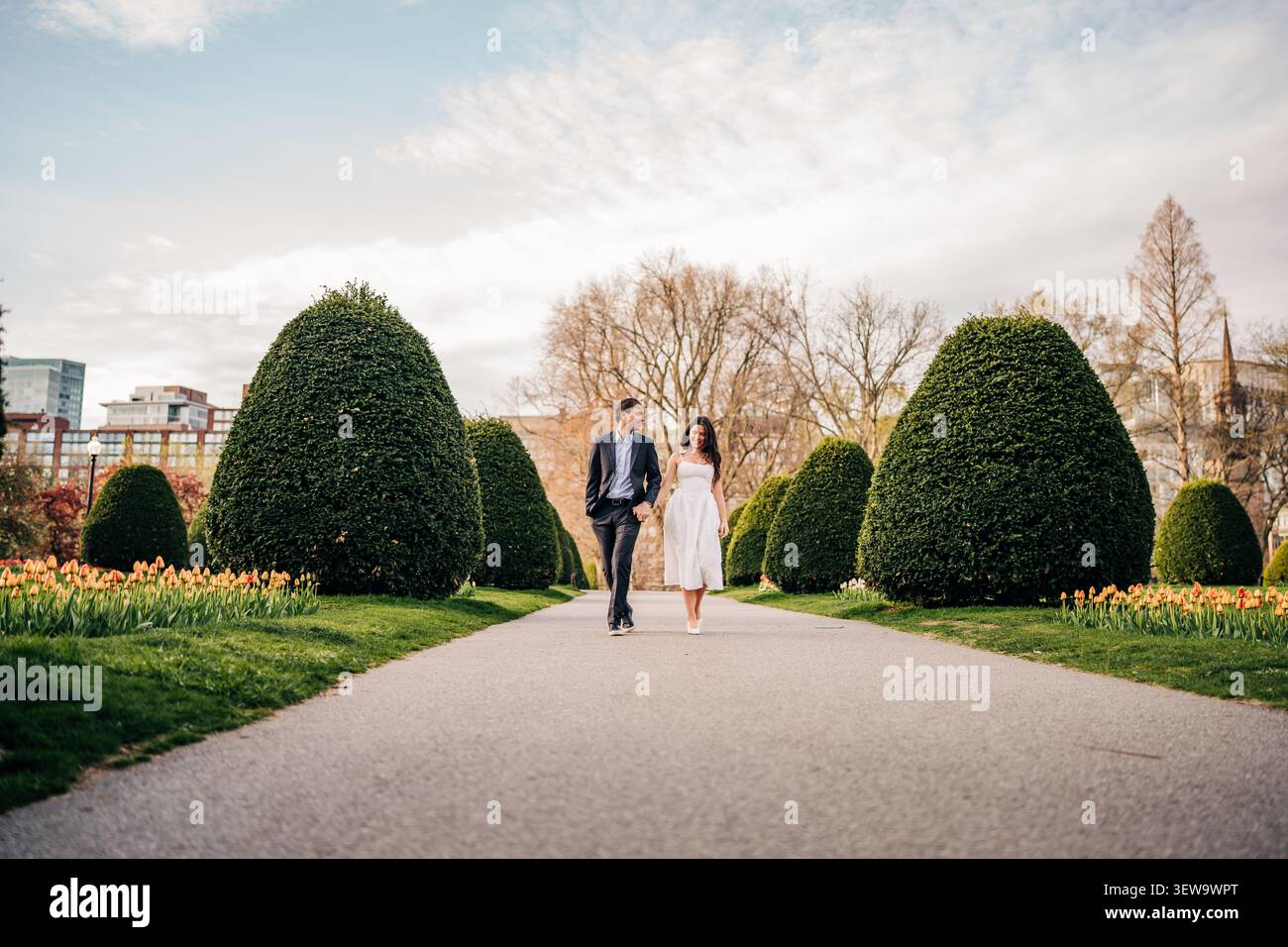 Happy couple walking hand in hand through a park Stock Photo