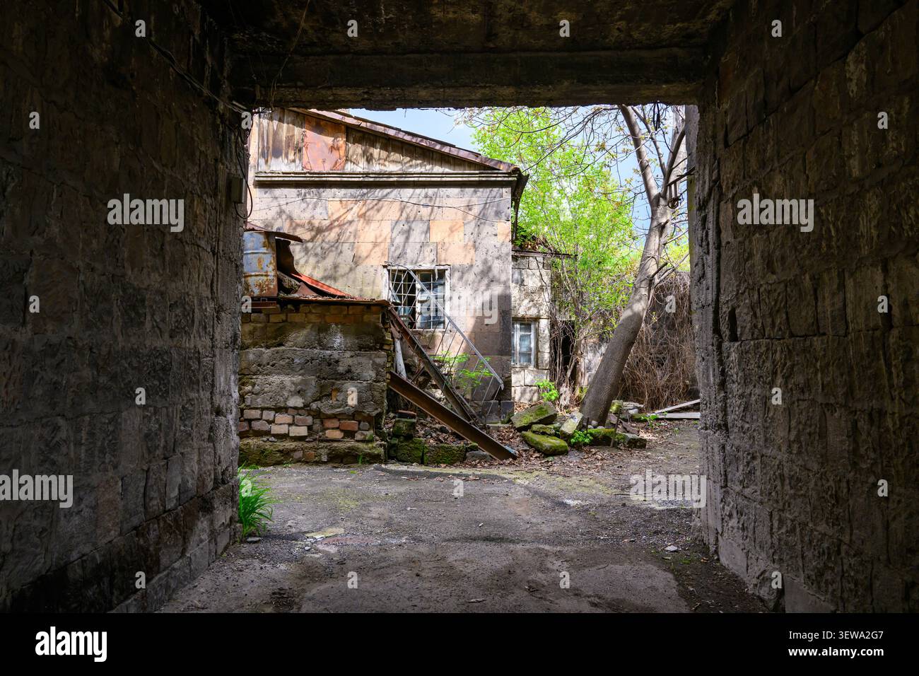 Weathered stone archway frames abandoned building Stock Photo