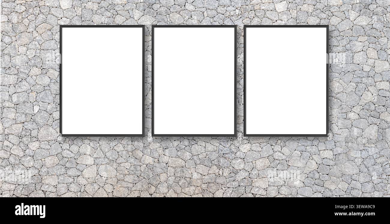 Three empty frames hanging on a textured grey stone wall, providing copy space Stock Photo