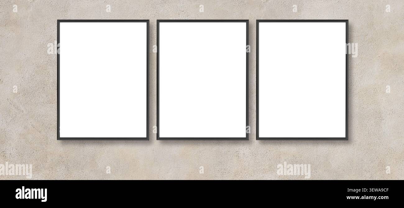 Three black empty frames hanging side by side on a textured concrete wall, offering copy space Stock Photo