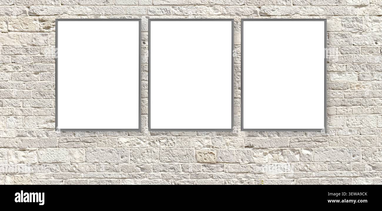 Three empty frames offering copy space on a textured white brick wall background Stock Photo