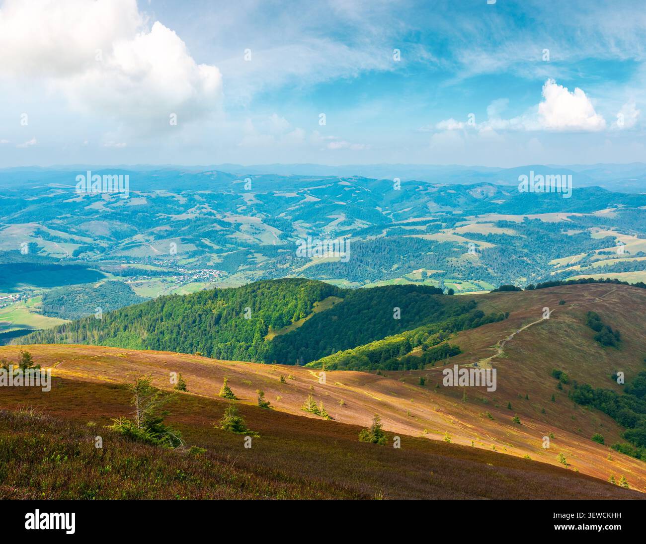 mountainous countryside scenery in the afternoon. view of cloudy sky above the valley. colorful meadows and trees on hill in dappled light. beautiful Stock Photo