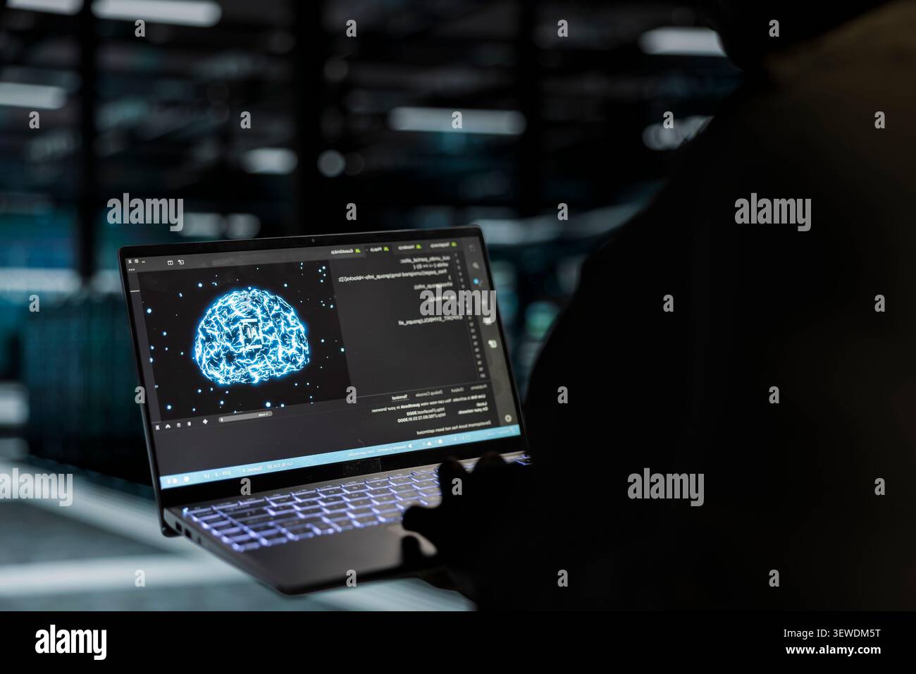 Computer scientist works with a computer workstation in a server hub to support artificial intelligence systems. Stock Photo
