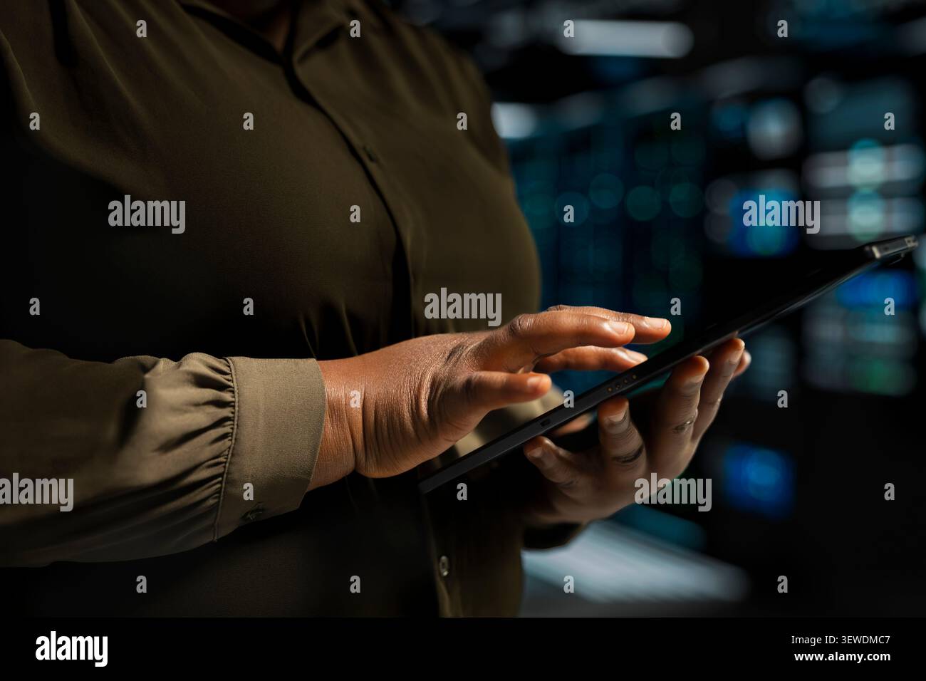 IT expert provides technical support from a data center using a headset while troubleshooting client server issues. Stock Photo