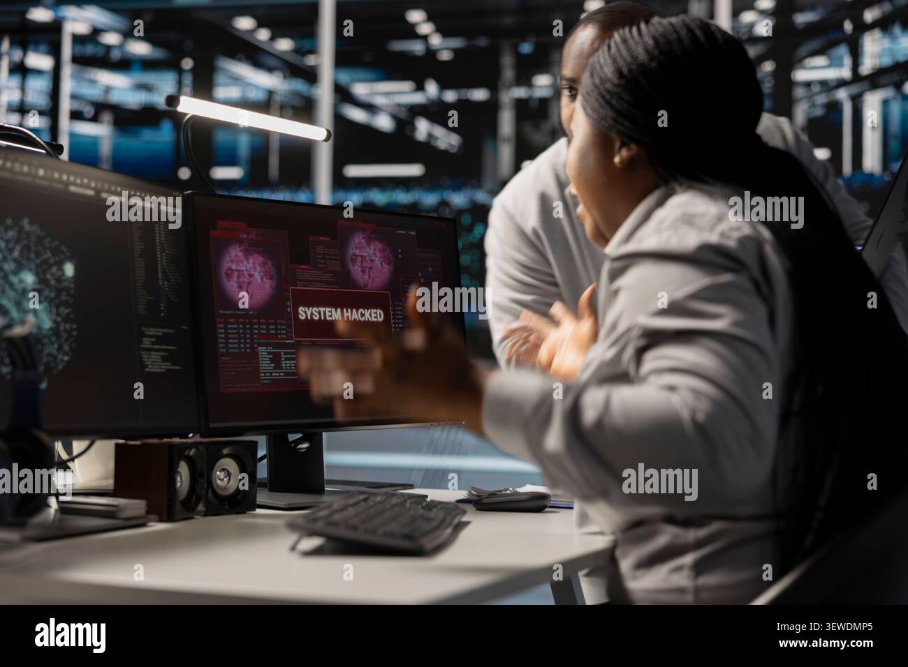 Pensive data center technicians review system data in a data center while planning repairs for performance and hardware issues. Stock Photo