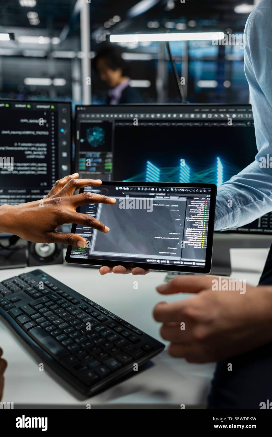 Data center team works with digital tablet in a data center to support data processing, analytics, and storage infrastructure. Stock Photo