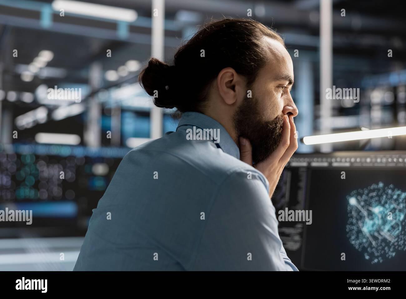 Data scientist uses a desktop computer in a data center to manage AI visualization and optimize server infrastructure. Stock Photo