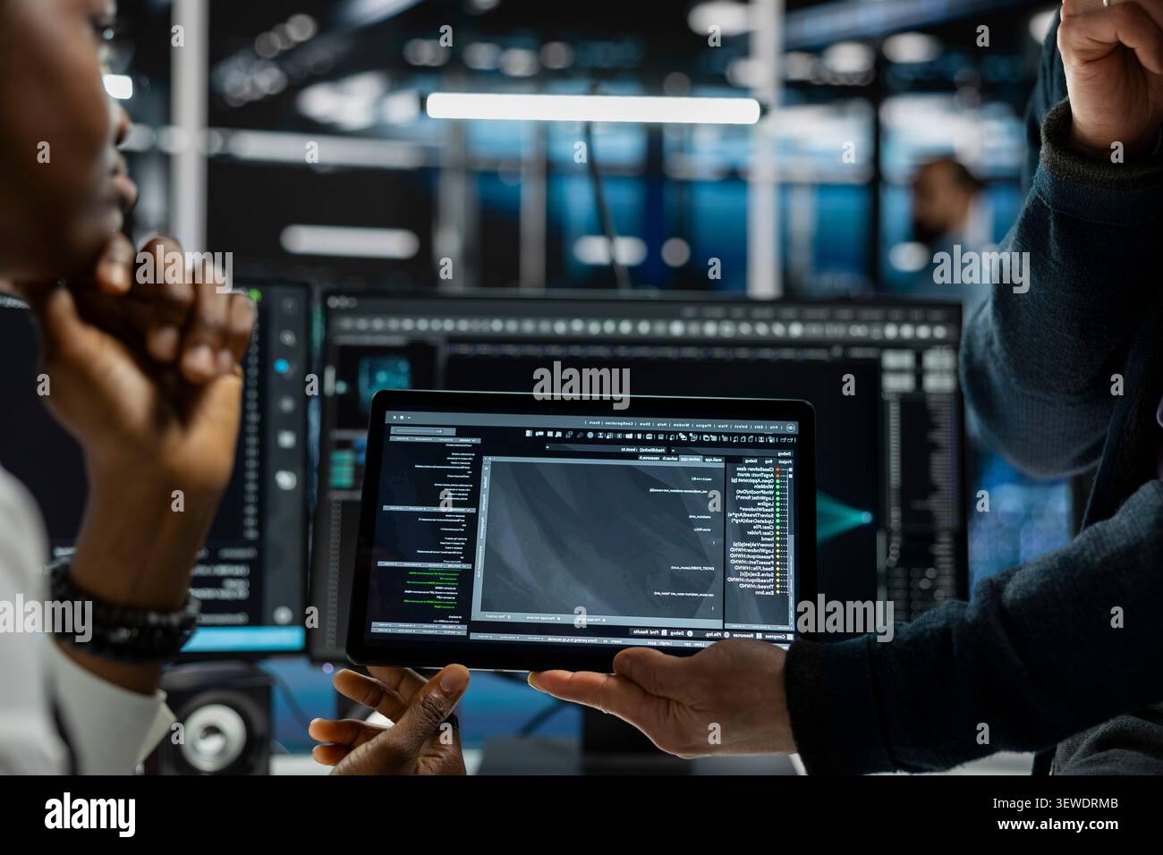 Data center programmers use a digital tablet in a data center to run hardware diagnostics and maintain operational stability. Stock Photo