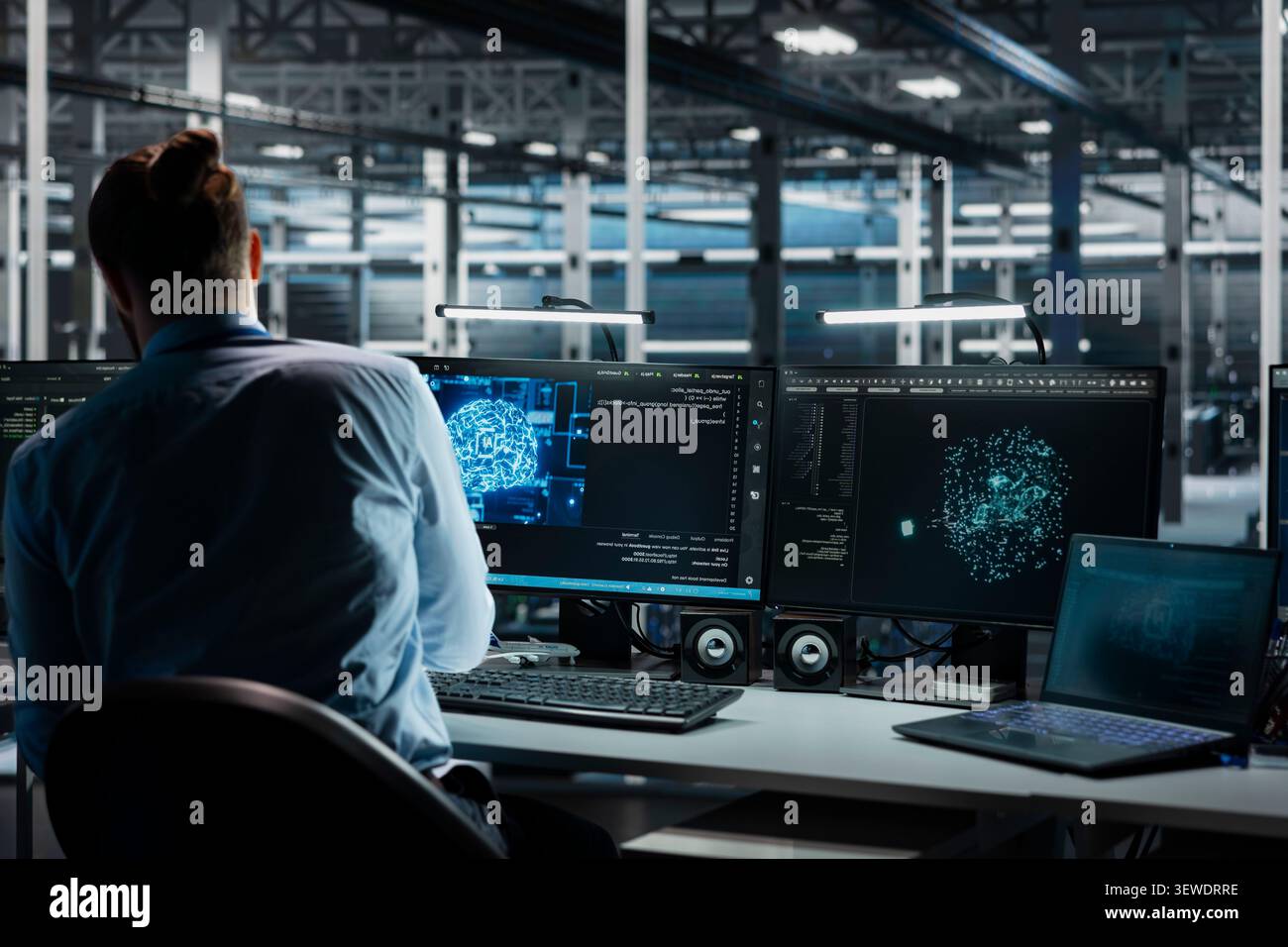 Software developer reviews artificial intelligence systems and machine learning processes inside a data center. Stock Photo