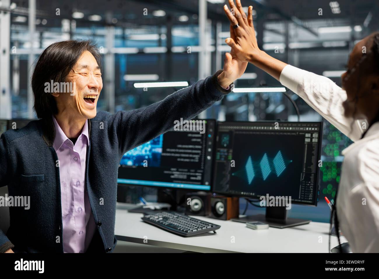 Engineers celebrate in a server hub after successfully programming with generative AI assistance. Stock Photo