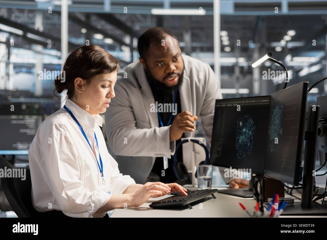 Data center colleagues collaborate on coding and AI automation scripts while reviewing server infrastructure together. Stock Photo