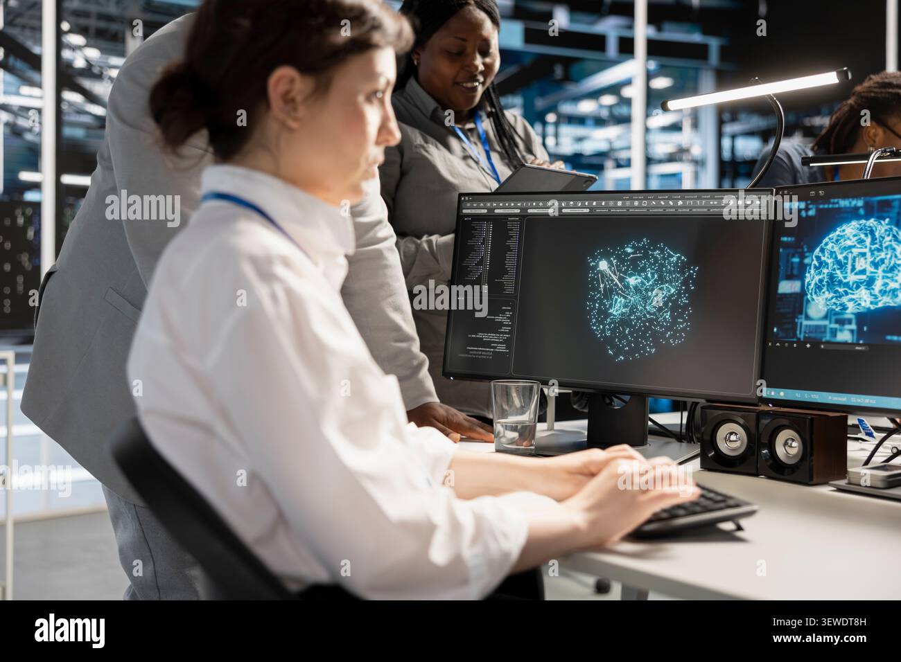 Data center colleagues collaborate on coding and AI automation scripts while reviewing server infrastructure together. Stock Photo