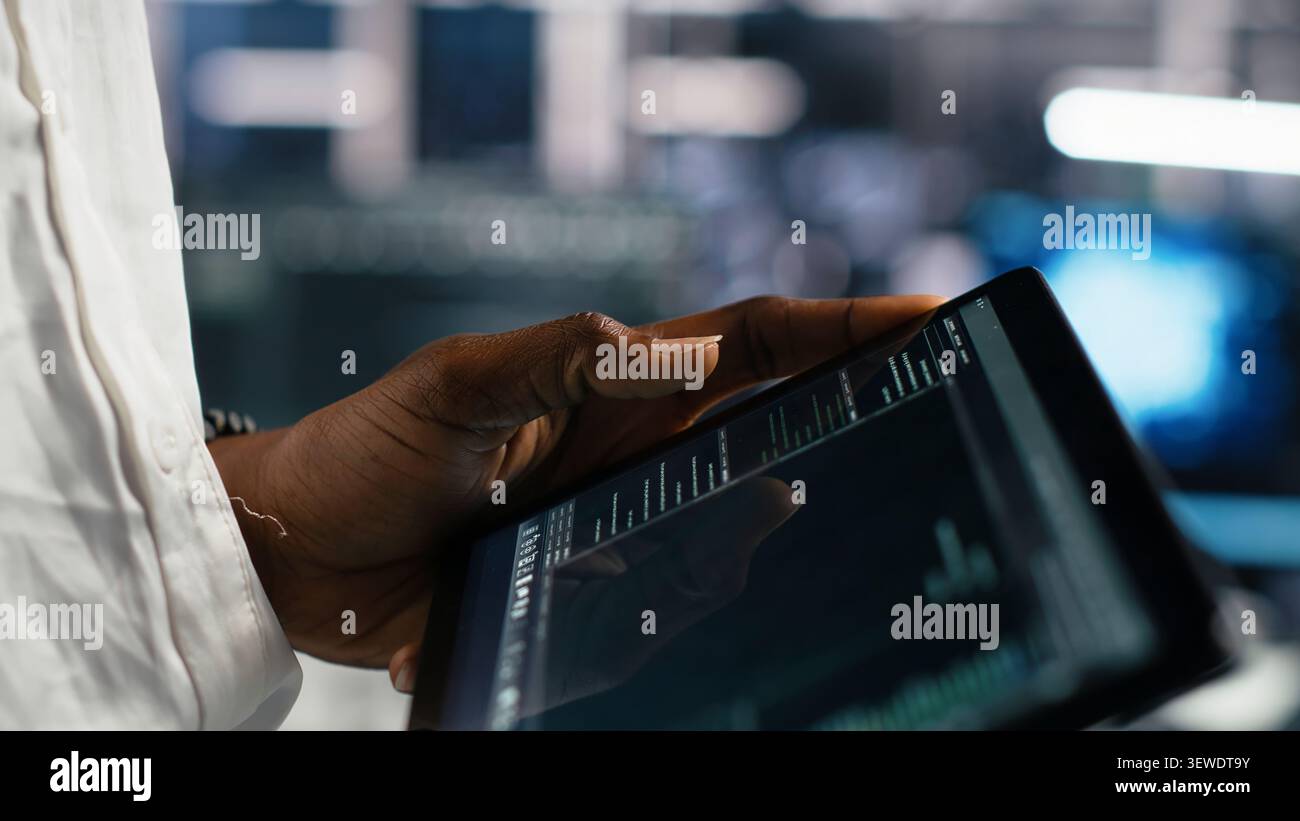 Server facility software developer working with tablet to review code for automation scripts. Stock Photo
