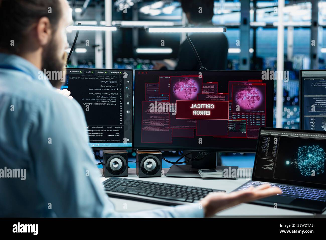 Software developer works with a computer workstation in a server room to support artificial intelligence systems. Stock Photo