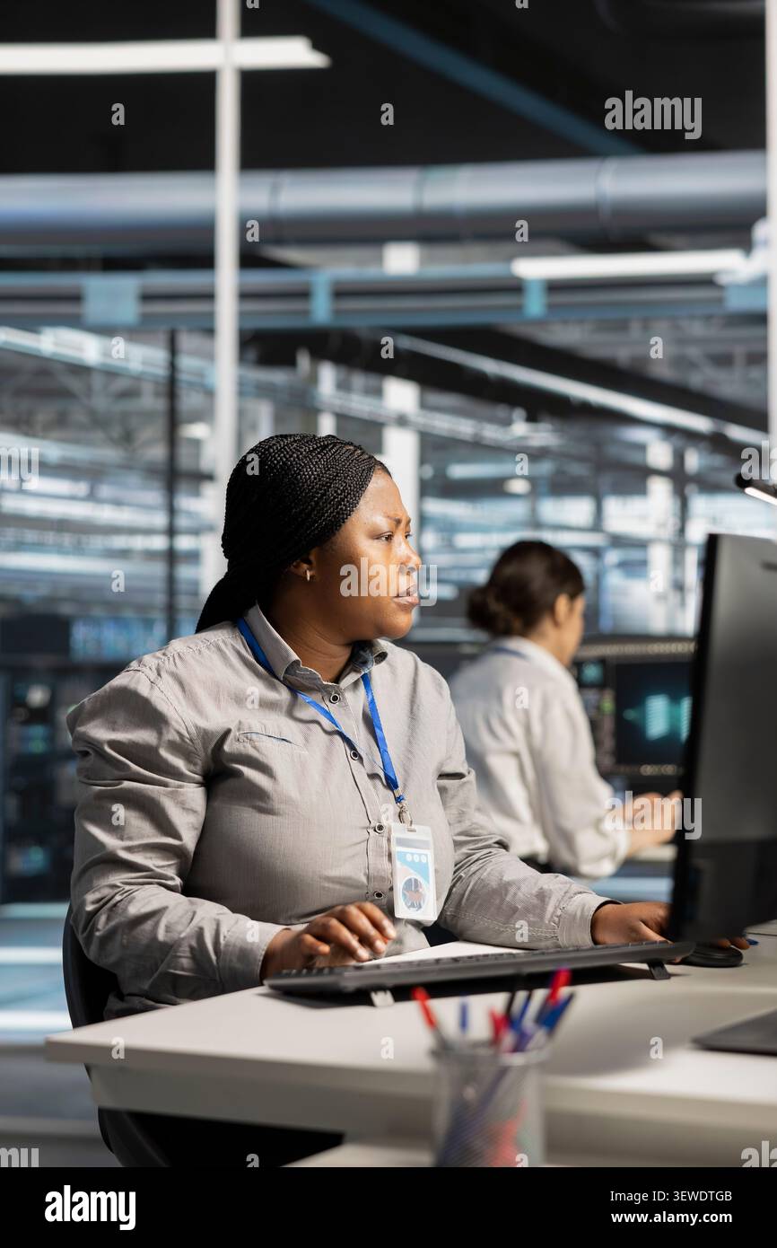Software developer uses a computer to run diagnostics, update servers and check infrastructure performance. Stock Photo