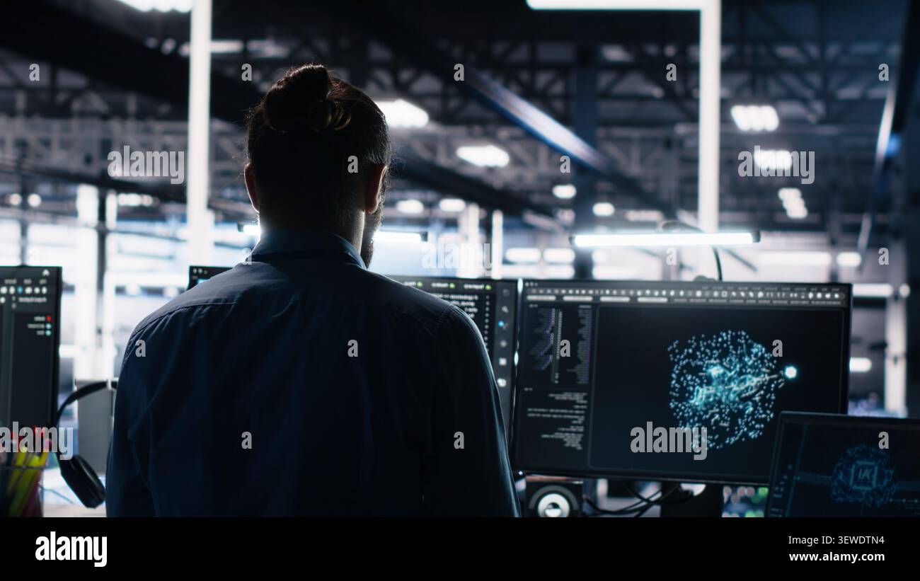 Overjoyed data center engineer dances on a chair after successfully analyzing datasets with machine learning tools. Stock Photo