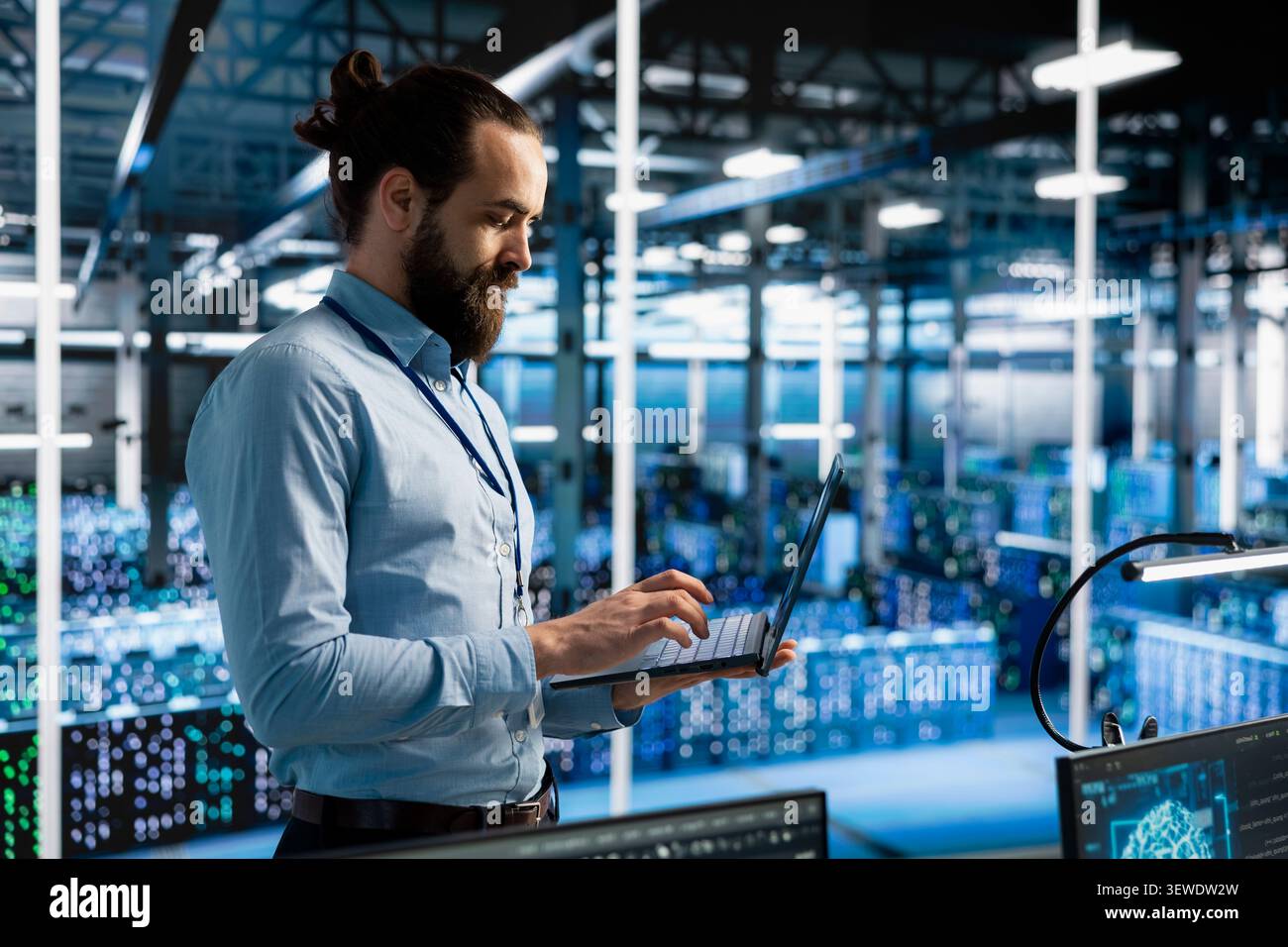Data center programmer manages databases supporting AI applications and data mining in a server facility. Stock Photo