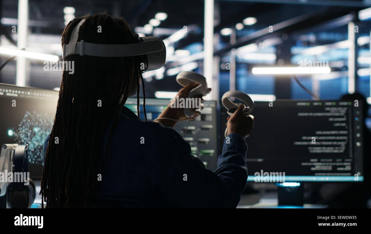 Data center technician uses a VR headset to analyze datasets and manage AI database workflows in a server room. Stock Photo