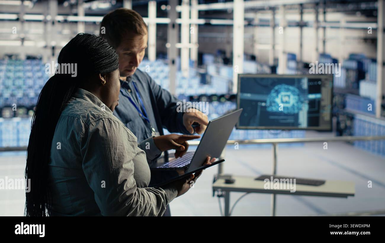 Data center engineering team manages software updates in a server room to keep data center systems stable. Stock Photo