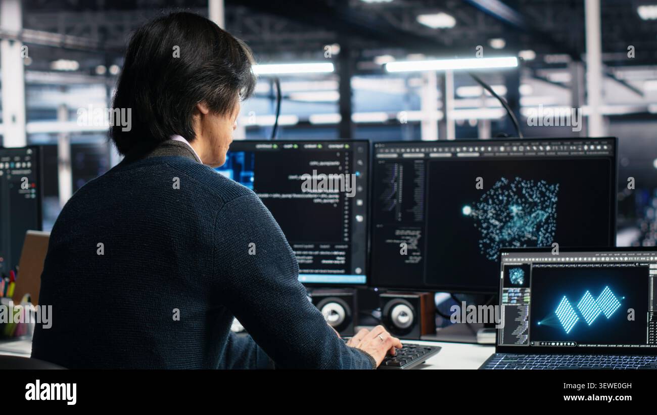 System administrator uses deep learning tools on a digital device in a server room to improve AI operations and system efficiency. Stock Photo