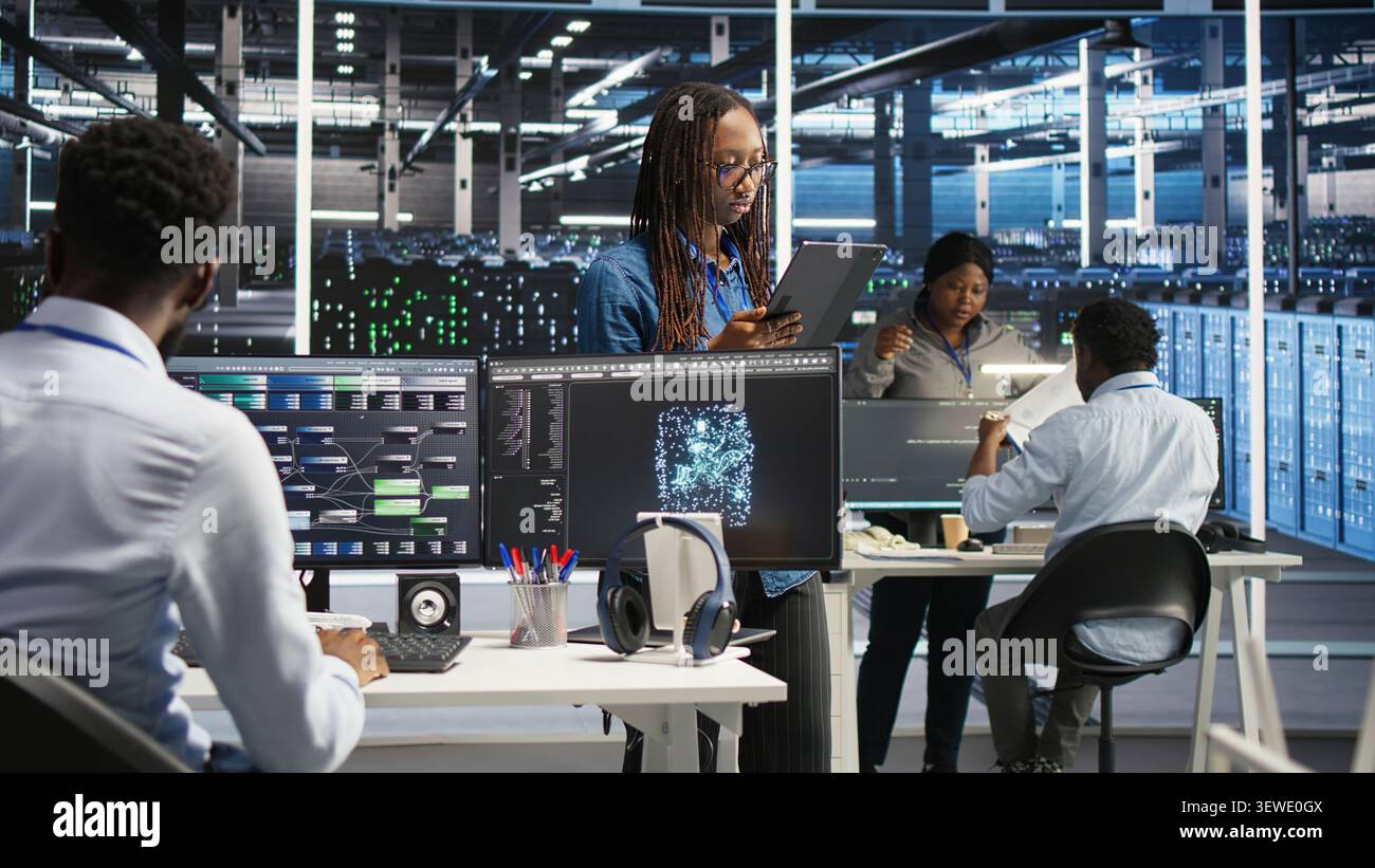 Engineer uses a computer workstation in a server farm to categorize unstructured data with node tree systems. Stock Photo