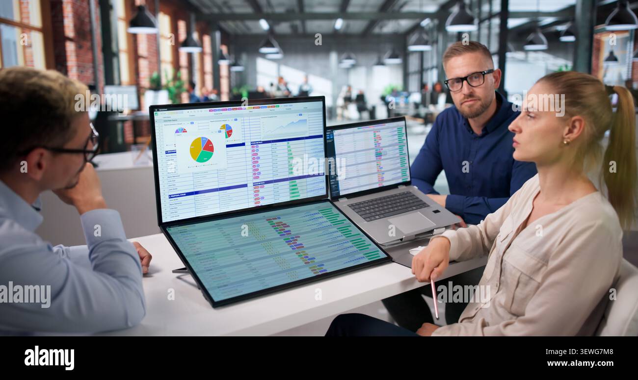 Medical Coder Team Works Together Reviewing Billing Codes On Laptops. Stock Photo