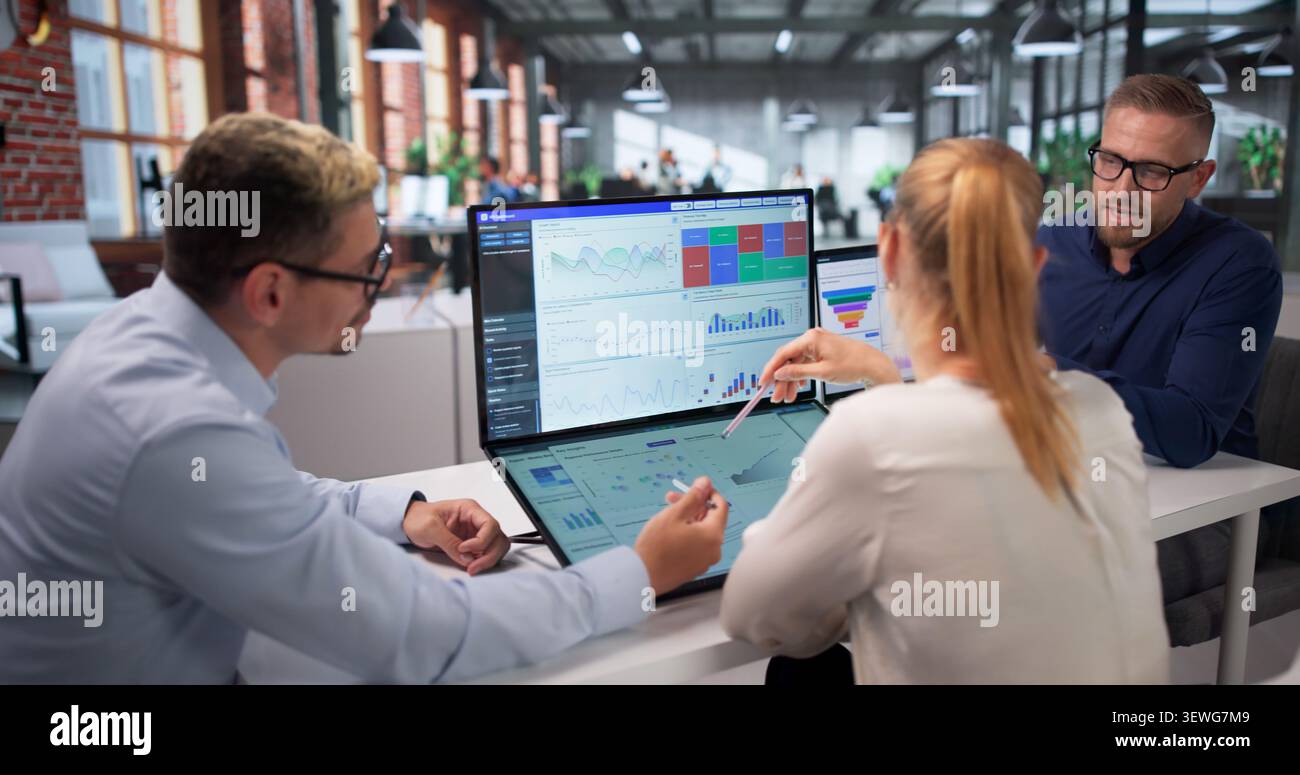 Three Data Analysts Working Together On Financial Dashboard Insights. Stock Photo