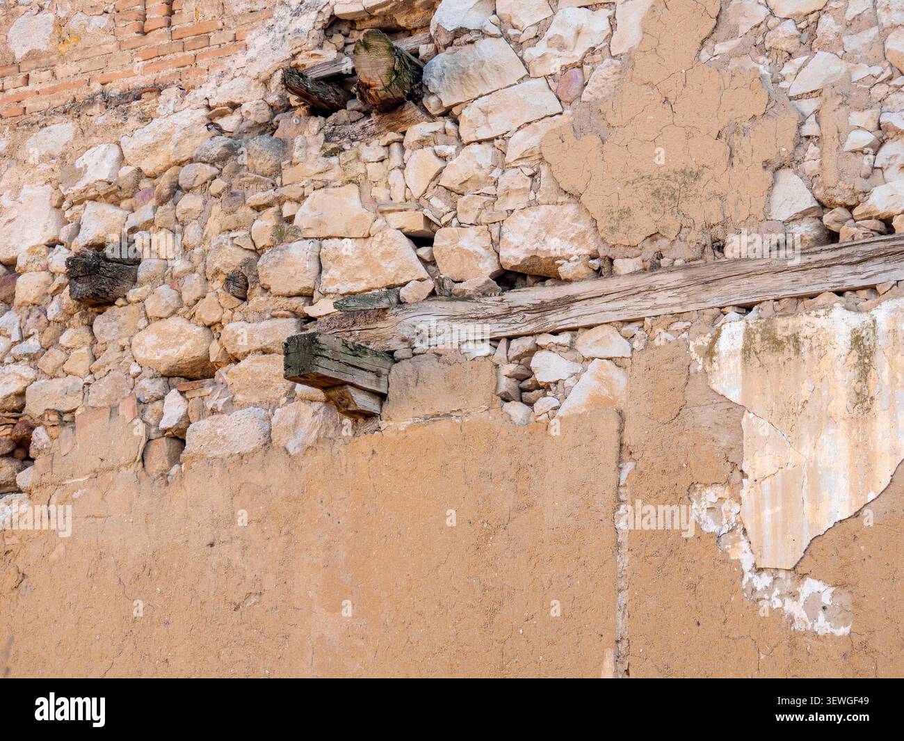 Weathered texture of an ancient wall with visible stone, mud, and timber elements Stock Photo